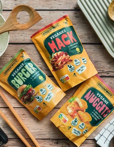 Verpackte vegane Produkte von Greenforce: Burger, Hack und Nuggets auf Holzuntergrund