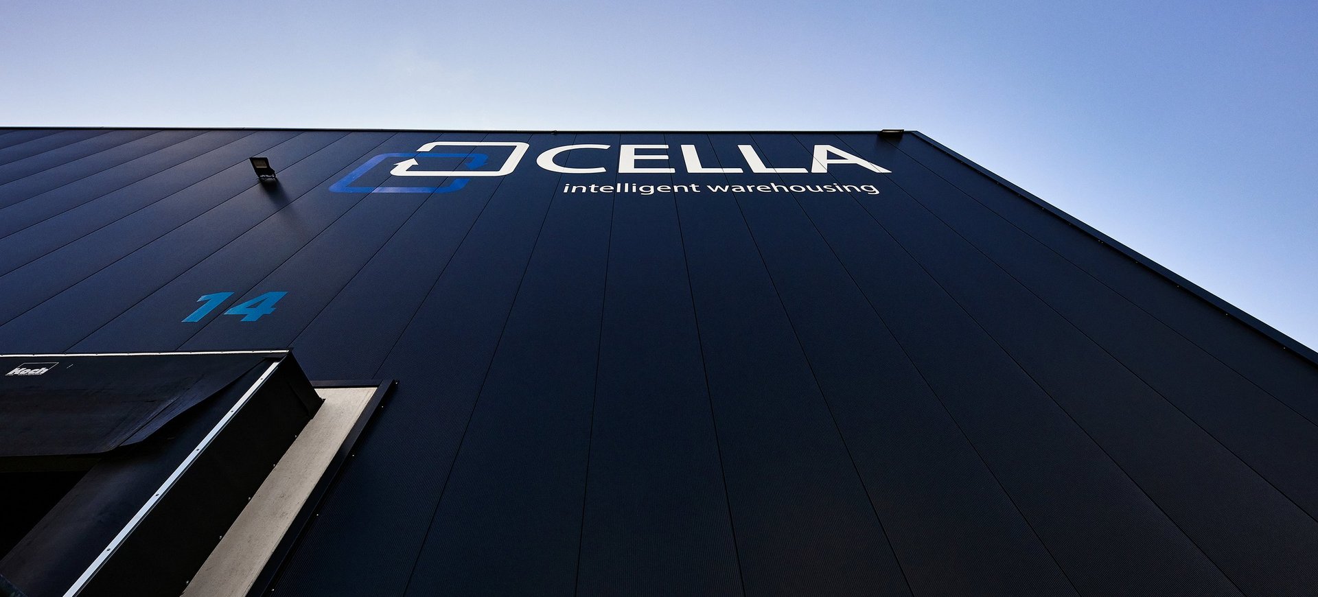 Gebäudefassade mit Logo von Cella GmbH und Slogan „intelligent warehousing“ 