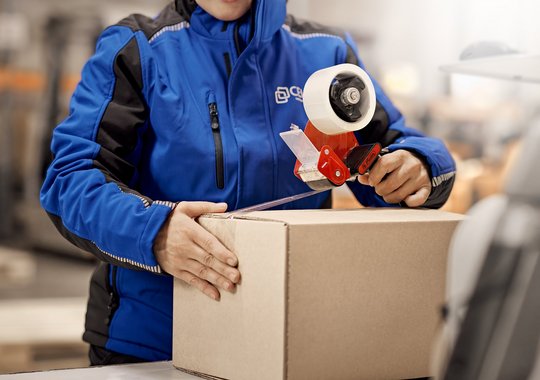 Cella-Mitarbeiterin verpackt ein Paket im Lager