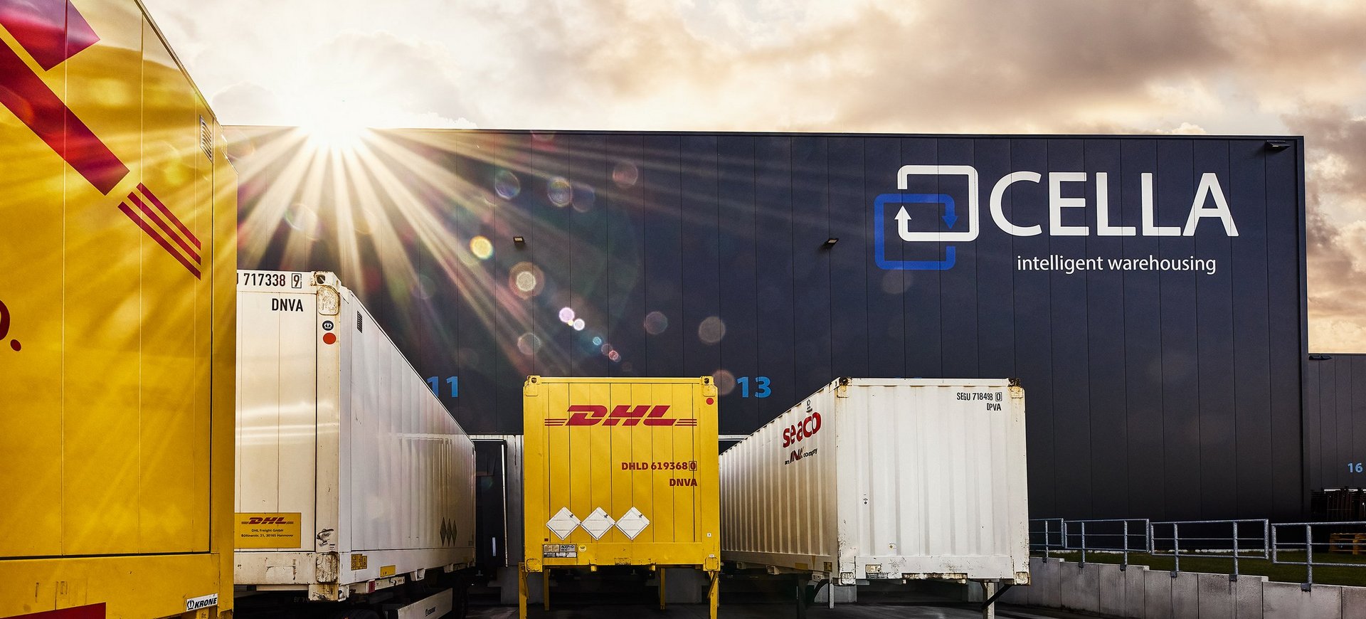 DHL-Lkw vor dem Cella-Logistikzentrum in Meppen bei Sonnenaufgang 