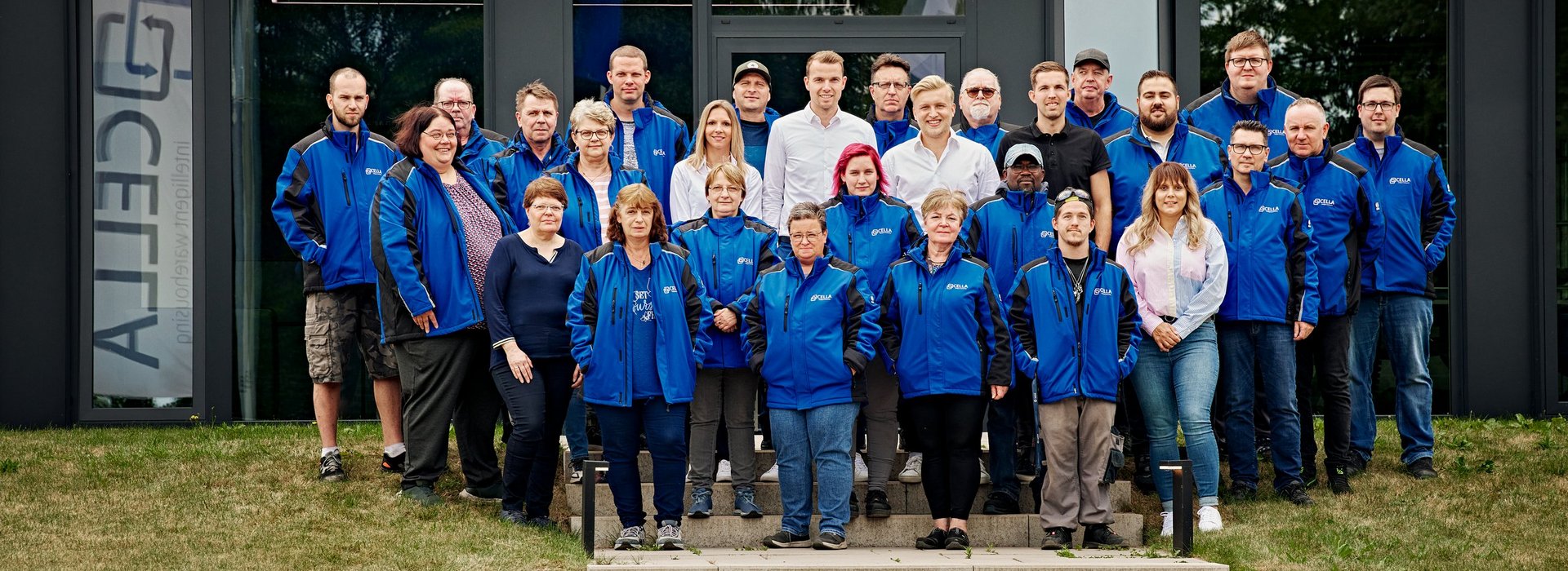 Teamfoto der Cella-Mitarbeiter vor dem Gebäude 
